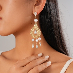 Vintage style drop earrings with faux pearls and rhinestones on a female model