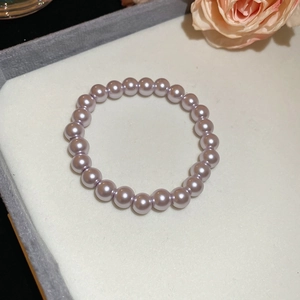 Close-up of lavender pearl beaded necklace with elegant luster on white jewelry stand