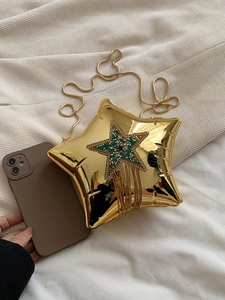 Detail of gold star-shaped chain bag with rhinestone fringe and sleek metallic finish