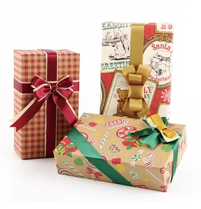 Three Christmas gift boxes wrapped in vintage kraft paper with elegant silk ribbon bows