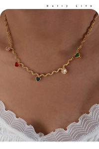 Detail of gold twisted chain necklace featuring five colorful heart-shaped zircon pendants