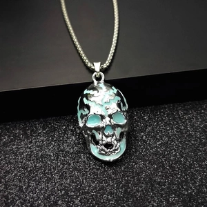 Men's hip hop luminous skull necklace in silver with light blue glow on black texture