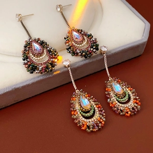 Macro shot of silver needle tassel earrings with zircon crystals and vintage drop stones