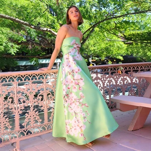 Nahaufnahme des hellgrünen Satin-Abendkleids mit elegantem rosa Blumendruck und bodenlangem Saum