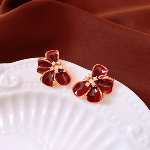 Detailed view of burgundy flower stud earrings with 18K gold plating and zircon centers