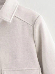 Close-up of cream white wool jacket collar and shoulder stitching details