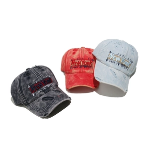 Detailed close-up of embroidered New York patch on distressed washed cotton baseball caps