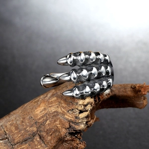 Detailed view of vintage punk dragon claw ring on rustic wood background texture