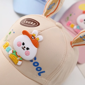 Detailed close-up of a beige cotton baby baseball cap with 3D bunny ears and silicone rabbit
