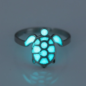 Detailed macro view of turtle ring with luminous glowing blue shell in dark