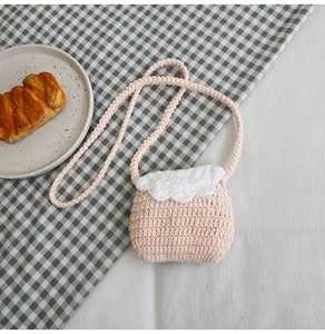 Close-up of pink and white hand-crocheted flower mini shoulder bag with soft knit texture