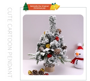Mini flocked Christmas tree with bells, pine cones, and a wooden base on white backdrop