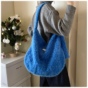 Blue faux fur hobo bag shown in side view on model with plush texture details