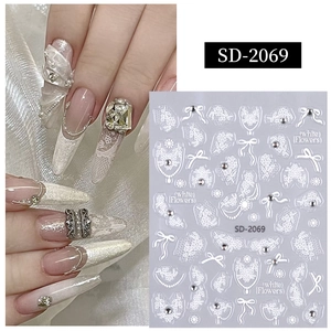 Détail de stickers à ongles 5D avec dentelle blanche, nœuds et texture de perle en 3D