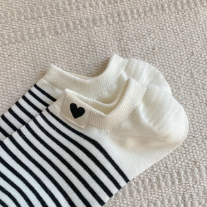 Close-up of knit cotton low-cut ankle socks with black stripes and heart patch detail