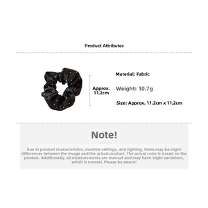 Detailed view of black and white polka dot scrunchie with dimensions 11.2cm and 10.7g weight
