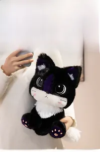 Close-up of a cute black and white plush cat toy with purple accents being held by hands