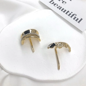 Detailed view of gold minimalist hair pins with hammered texture on a stone base