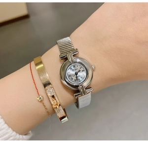 Detailed view of elegant ladies' silver quartz watch with Roman numeral dial on wrist.