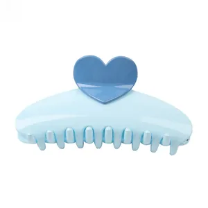 Detail of light blue heart claw clip with dark blue heart patterns and smooth teeth
