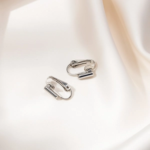 Macro di convertitori per orecchini a clip in argento su elegante seta bianca pura