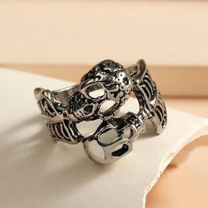 Macro dettaglio di anello a teschio gotico vintage su un piedistallo di pietra bianca
