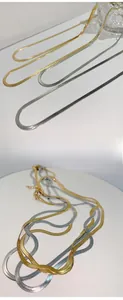 Detail of gold and silver snake bone chain necklaces showing smooth metal texture