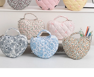 Collection of heart-quilted floral cosmetic bags with handles in various patterns