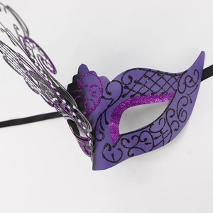 Macro detail of purple butterfly masquerade mask with glitter finish and black lace patterns