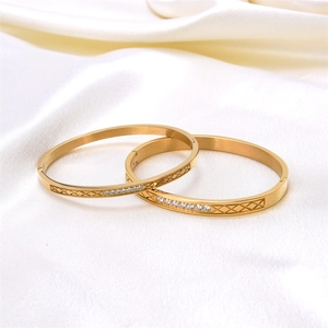 Luxe gold-plated stainless steel cuff bracelets with CZ stones on white silk