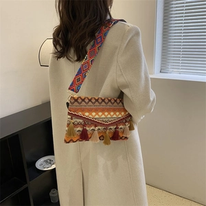 Close-up of Bohemian crossbody bag with colorful woven strap and multicolor fringe details