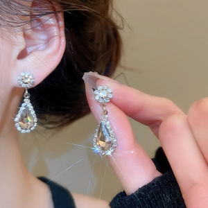 Detailed view of champagne teardrop earrings with sparkling floral diamond accents