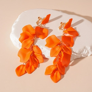 Detail of orange acrylic flower petal earrings with long tassel and gold metal chains