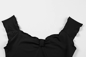 Detail of black top with ruffled sweetheart neckline and ruched center stitching