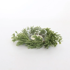 Close-up of a mini Christmas wreath with green pine needles and a white tea light candle