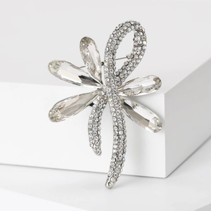 Detailed shot of a silver floral bow brooch featuring large crystals and pavé rhinestones