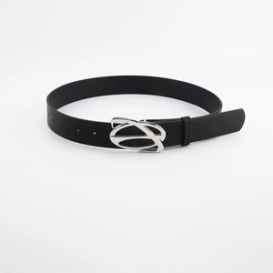 Detail view of high-quality black leather belt with unique silver metal buckle for women