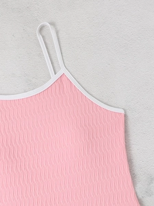 Detail of pink backless swimsuit featuring 3D wave texture fabric and white contrast binding