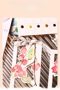 Close-up of watercolor bookmarks with pre-punched holes for hanging ribbons or tassels