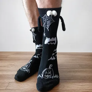Detail of Halloween socks with spider web and pumpkin patterns featuring 3D eyes