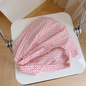 Gros plan sur le motif de petits nœuds rouges du sac en toile de coton blanc pur