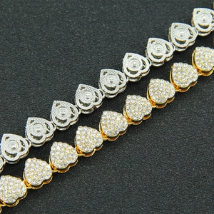 Detail of silver and gold heart-shaped Cuban link bracelets with sparkling cubic zirconia