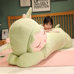 Close-up of large plush lamb in green sweater on bed showing soft sherpa texture