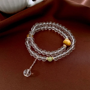 Detail of double-layer beaded bracelet with tiger eye stone on dark brown silk fabric