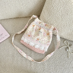 Détail du sac seau à cordon floral avec dentelle et base à carreaux roses