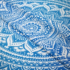 Gros plan sur le tissu d'une tapisserie mandala bleu et blanc et sa texture tissée