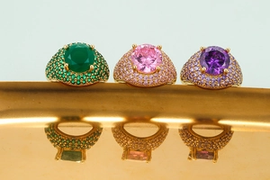 Detailed macro view of large round-cut pink, green, and purple micro-pave gold rings