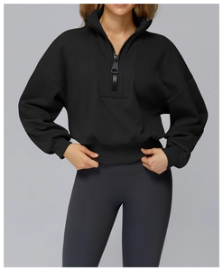 Detail of 1/4 zip collar and drop shoulder design on a black athletic sweatshirt
