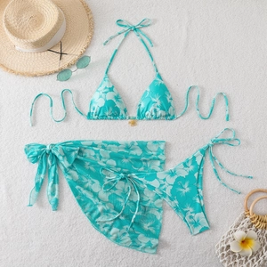 Detail of three-piece turquoise hibiscus floral bikini set with matching beach sarong