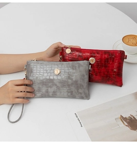 Close-up view of crocodile embossed clutch bags with crystal embellished hardware